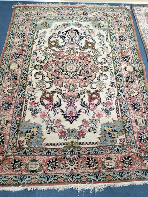 A part silk Isfahan cream rug with central floral scroll medallion, 196 x 140cm